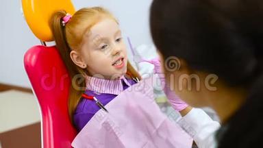 孩子们`牙医在一张<strong>黄红色</strong>的牙椅上检查一个可爱的红发小女孩的牙齿和嘴。